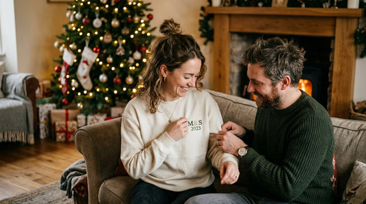 Couple examining embroidered sweatshirt with year and initials.